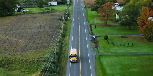 A school bus driving in a rural neighborhood